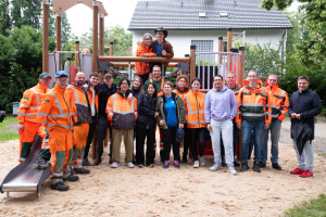  Gemeinsam bei der Spielplatz-Einweihung (von rechts): Bezirksbürgermeister Frederik Suchla, Gärtnermeister Dietrich Kopp (UWB), Abteilungsleiter Sebastian Richter (UWB), Dirk Althoff (UWB) sowie Gärtner des UWB und die elf freiwilligen Helferinnen und Helfer.  